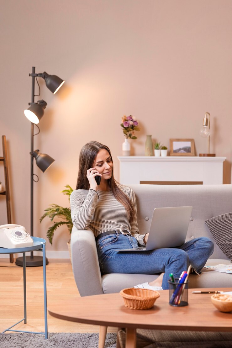 long shot woman sitting couch works 23 2148515901